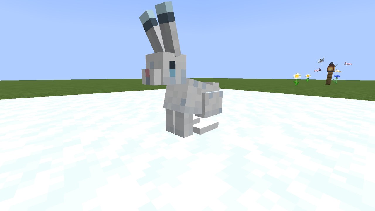 A white hare with long dark-tipped ears and big dark eyes, sitting on snow