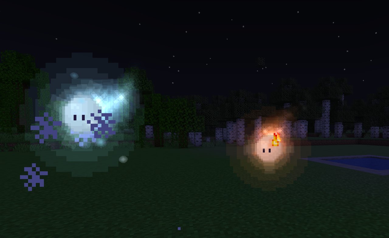 Two wisps close up at night: a pale blue one with sparkling motes and a small orange one with a flame