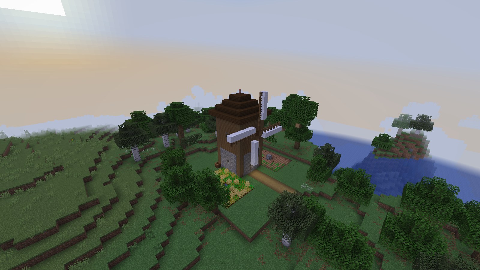 A windmill farmstead on a grassy hill: a cobblestone and plank tower with a dark roof and white sails, a wheat plot and a path to the door